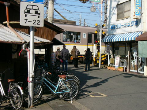 踏み切りで待つ乗り換え客